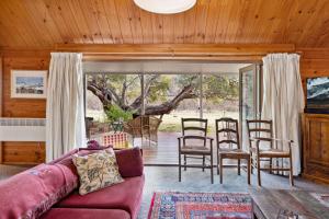 ein Wohnzimmer mit Sofa, Tisch und Stühlen in der Unterkunft Bimberdong House in Crackenback