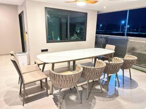 a white table and chairs in a room with a window at Reniva Pool Villa cha-am in Ban Bo Prakhon