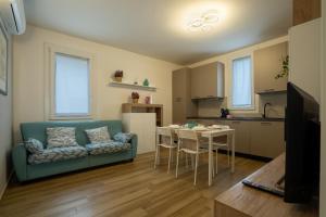 a living room with a blue couch and a kitchen at Tra il verde ed il Balsamico in Spilamberto