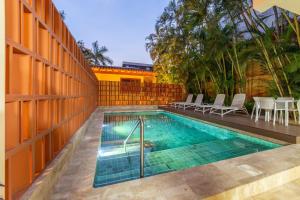 a swimming pool with chairs next to a fence at Casa Riviera in Bucerías