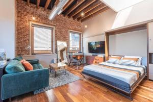 a bedroom with a bed and a couch at Stylish SOHO-Inspired Loft, 15 Min to NYC Times Square in Union City