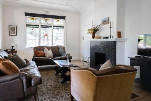 un soggiorno con divani e camino di Poets Corner vintage retreat walk to View St a Bendigo