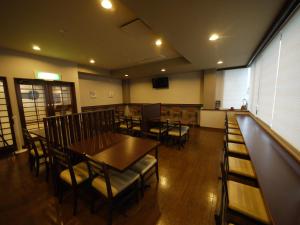 a dining room with tables and chairs and a bar at Hotel Route-Inn Court Kofu Isawa in Fuefuki