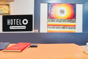 a hotel sign on a wall next to a desk at Super Hotel O JLN Marg Malviya Nagar Formerly Hotel Braj Haveli in Jaipur