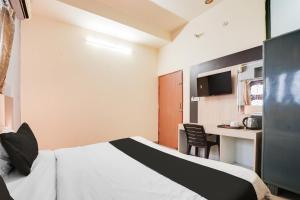 a hotel room with a bed and a desk at Super Hotel O JLN Marg Malviya Nagar Formerly Hotel Braj Haveli in Jaipur