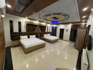 a hotel room with two beds and a ceiling at Dream Inn Guest House Islamabad in Islamabad