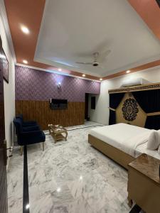 a hotel room with a large bed and a tv at Dream Inn Guest House Islamabad in Islamabad
