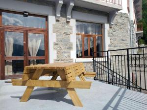 a wooden bench sitting in front of a building at Location Paradiski San Bernardo in Séez