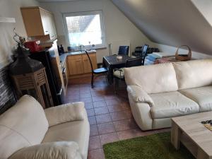 a living room with two white couches and a kitchen at Ferienwohnung am Teich in Lütow