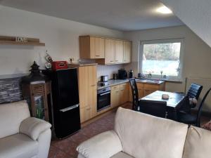 a kitchen with a couch and a table in a room at Ferienwohnung am Teich in Lütow +3 photos