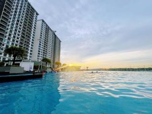 a swimming pool next to some tall buildings at Spacious Cozy Studio 1-3 Pax at D Secret Garden - Kempas-Setia Tropika-JB Centre-Mid Valley-Paradigm-UTM, Business Welcome in Johor Bahru