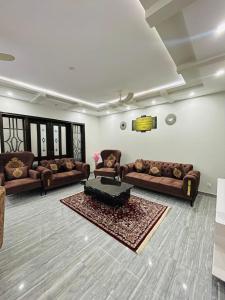 a living room with couches and a coffee table at Dream Inn Guest House Islamabad in Islamabad