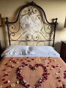 a heart made out of roses on a bed at Villa Poggio dei Cipressi in Subbiano