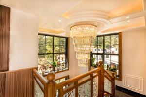 a large staircase with a chandelier and windows at Alivaa Hotel, McLeodganj With Best Dhauladhar View & Infinity Pool Sky Garden in McLeod Ganj