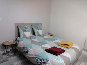 a bedroom with a bed with a colorful comforter and pillows at Appartement climatisé avec parking privé gratuit in Doué-la-Fontaine