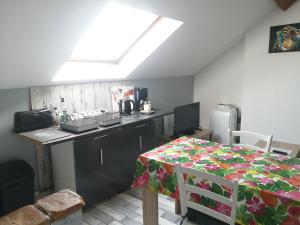 a kitchen with a counter top and a table with a tablecloth at Appartement climatisé avec parking privé gratuit in Doué-la-Fontaine