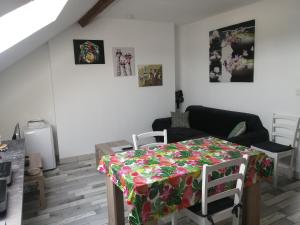a living room with a table with a flowered table cloth at Appartement climatisé avec parking privé gratuit in Doué-la-Fontaine