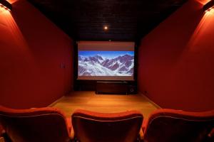 レ・ズッシュにあるChalet Luxe, vu massif exceptionnelの椅子付きの部屋に大画面のステージ
