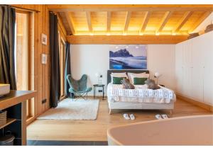 a bedroom with a bed and a bath tub at Chalet Croc Blanc, Chamonix - vu massif exceptionnel in Les Houches
