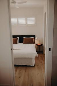 une chambre avec un lit blanc et une fenêtre dans l'établissement Dudley Villa, à Evans Head