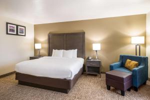 a hotel room with a bed and a blue chair at Comfort Inn Bossier City Casino Area near Shreveport Downtown in Bossier City +26 photos