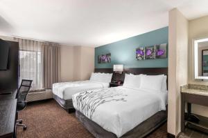 a hotel room with two beds and a television at Sleep Inn Olathe - Kansas City in Olathe +30 photos