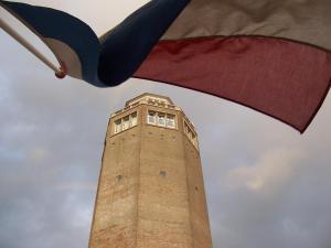 a tall tower with a flag in front of it at Pension & Spa de Watertoren in Zandvoort