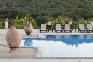 a swimming pool with chairs and a table at Villa Vesta in Noto