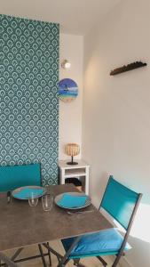 a dining room with a table and blue chairs at T2 West CITY Parking Clim Wifi 4pers - ROSSIconciergerie - Linge inclus in La Grande-Motte +14 photos