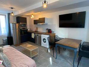 a living room with a couch and a table and a kitchen at La Petite Sancerroise in Jars +7 photos