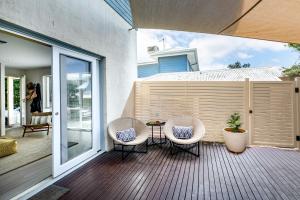 a patio with two chairs and a table on a deck at Lookout 100m to the Ocean and Pet-Friendly in Ocean Grove