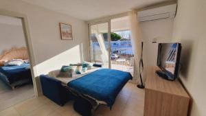 a bedroom with a bed and a tv in it at T2 West CITY Parking Clim Wifi 4pers - ROSSIconciergerie - Linge inclus in La Grande-Motte