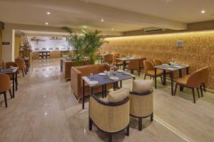 a restaurant with tables and chairs in a room at Grand Continent T Nagar in Chennai