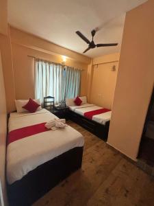 a hotel room with two beds and a ceiling fan at Hotel Fewa Lake View in Pokhara
