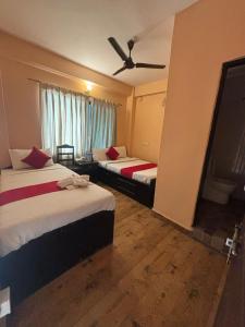 a hotel room with two beds and a ceiling fan at Hotel Fewa Lake View in Pokhara
