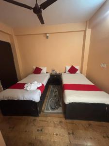 two beds sitting next to each other in a room at Hotel Fewa Lake View in Pokhara