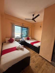 a hotel room with two beds and a window at Hotel Fewa Lake View in Pokhara