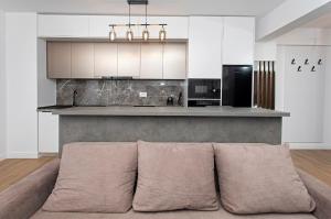 a living room with a couch in front of a kitchen at Panoramic Studio Oradea 2 in Oradea