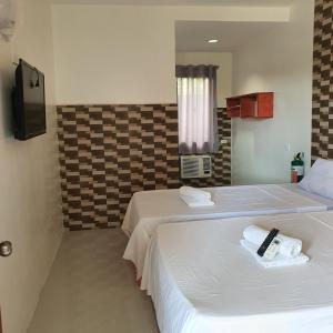 a hotel room with two beds with towels on them at AOSMECPoolCamp Hotel in Lapu Lapu City
