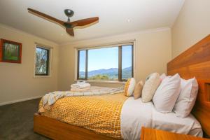 a bedroom with a bed with a large window at Kangaroo Lodge in Bright