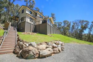 a large house on top of a hill with rocks at Kangaroo Lodge in Bright
