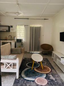 een woonkamer met een bank en een tafel bij Serenity Eusy Diani in Ukunda