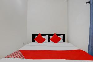 a bedroom with a bed with red pillows at Hotel O Casino in Nagpur