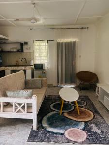 een woonkamer met een bank en een tafel bij Serenity Eusy Diani in Ukunda