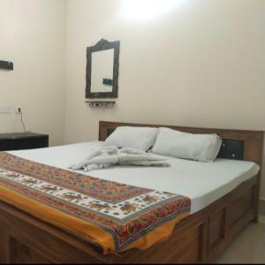 a bed with a blanket on top of it at Udita Homestay Prayas in Shānti Niketan