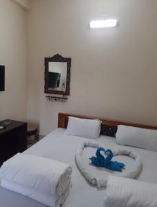 a bedroom with two beds with two blue hearts on them at Udita Homestay Prayas in Shānti Niketan