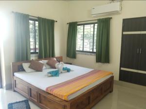 a bedroom with a large bed with green curtains at Udita Homestay Prayas in Shānti Niketan