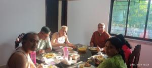 a group of people sitting around a table eating food at Udita Homestay Prayas in Shānti Niketan