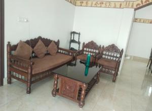 a living room with two couches and a table at Udita Homestay Prayas in Shānti Niketan