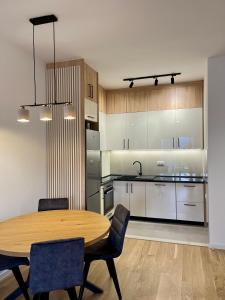 a large kitchen with a wooden table and chairs at Avenija apartman in Trebinje